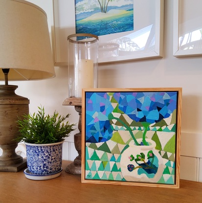 Small framed abstract of blue Hydrangeas in beige vase with geometric background 