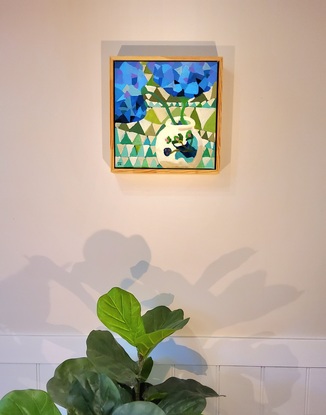 Small framed abstract of blue Hydrangeas in beige vase with geometric background 