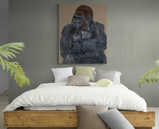 Relaxed gorilla sitting in front of a fabric background