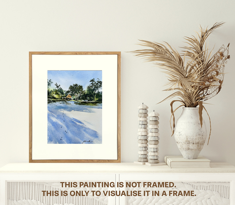 A view from the beach of a little cottage nestled amongst the trees with long shadows of the trees in the foreground.