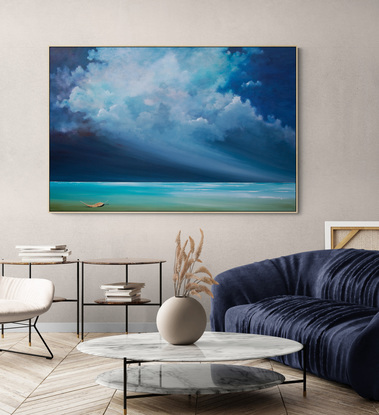 Dramatic and highly textured blue cloudscape over peaceful seascape with leaf suspending delicately over the water.