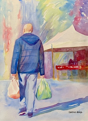 Man walking though market stalls.