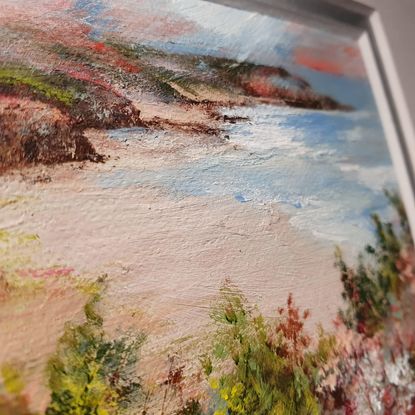 Mini oil painting of heathland above a distant seascape, in muted olive, silver tones and crimson reds. Framed in silver. 