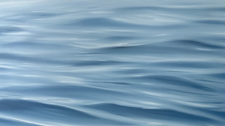 Ocean ripples under a dark grey sky