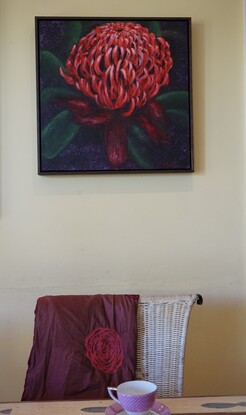 Large image of a single red waratah, dominating most of the canvas, with green leaves and dark background