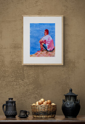 Man sits at the edge of the sea.