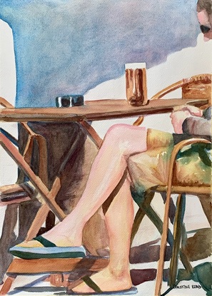 Man sits in a cafe with a beer.