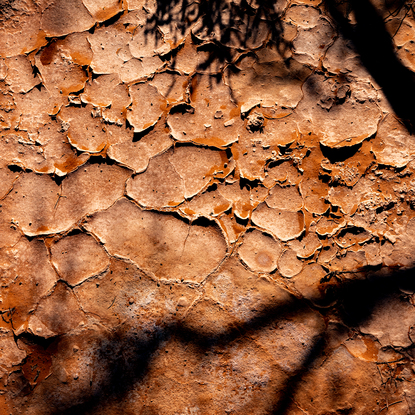 "Outback" photograph showcases rugged Australian wilderness with clay-like landscape and striking light and shadow play. Earthy terracotta tones dominate color palette for a captivating image.