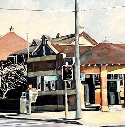 A street scene of the Strand, the main road through Croydon village. It shows the distinctive old post office which are prominent and iconic through many suburbs of the inner west of Sydney. The afternoon sun creates strong shadows off the two storey building of the street. To the left, a pair of a much longer row of palm trees frame the scene. 