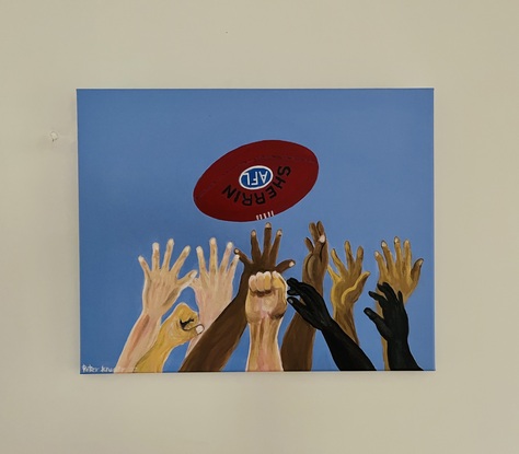 This is a painting showing arms and hands reaching out to catch a ball in Australian Rule Football game.
It shows the diverse races playing the game with the common aim of playing and winning for their team.