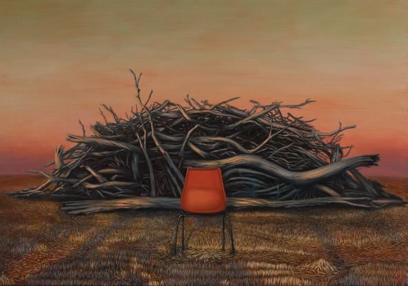 An empty red chair in front of a fire pile of logs