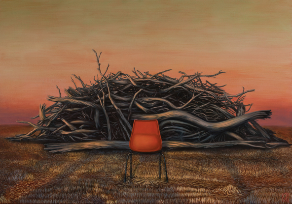 An empty red chair in front of a fire pile of logs