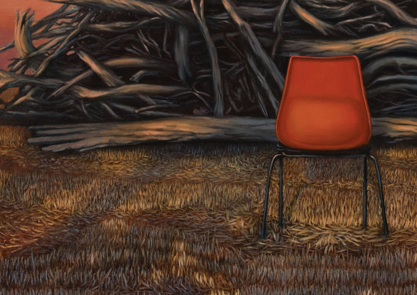 An empty red chair in front of a fire pile of logs