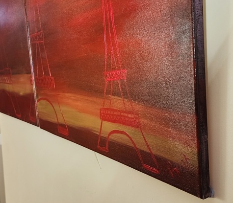 Three red coloured impressions of the Eiffel Tower,  on two canvasses, in close middle and far distance on a deep redish to very dark background with a yellow ochre strip highlight.