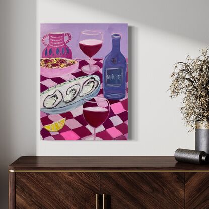 
In this painting: There is a glass of Wine, a plate of oysters, grilled fish, pickles ,lemons, tomatoes, flowers, tablecloth,pink vase,knives and forks and a tea towel with a sun on it.