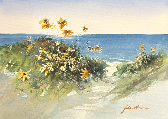 A beach scene with sunlight glistening on the water,  beach scrub and orange flowers in the foreground.