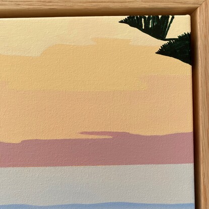 Pink and lemon sky over blue ocean with sand and grass in the foreground.