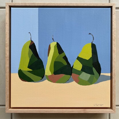 3 green pears in a row on a peachy coloured surface before a cool grey background.