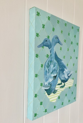 Two blue ducks on a diamond patterned background with four-leafed clovers.