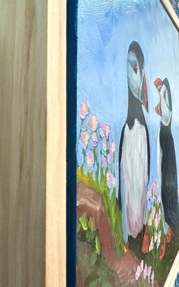 An oil painting of two puffins.