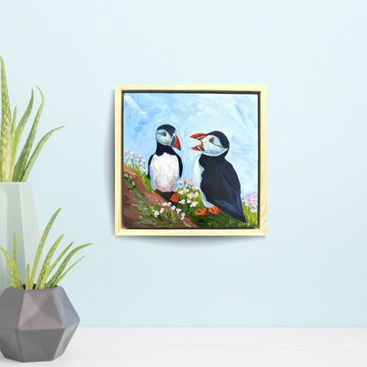 An oil painting of two puffins.