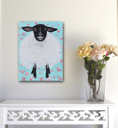 A textured painting of a black and white Suffolk Sheep on a green floral background. The woolly sheep was painted with a palette knife giving a thick woolly texture. He has long black ears, with a black face and black legs.