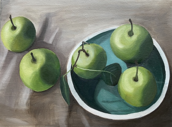 Green Apples on a blue plate and table with table cloth. Still life.