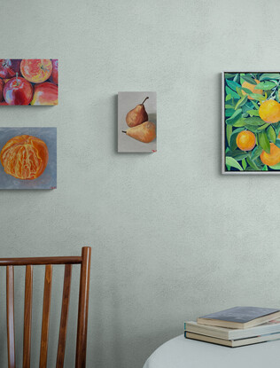 Two brown pears sitting next to each other on an off white background