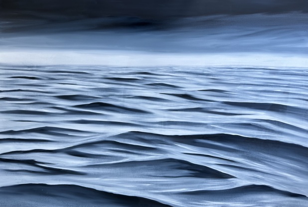 Black and white ocean surface under a dark sky