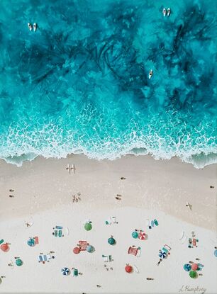 Surfers come and go from the ocean and sunbathers stretch out along the beach to enjoy the sun.