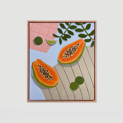 Papaya and limes on a blue table with apricot and brown tea towels. 