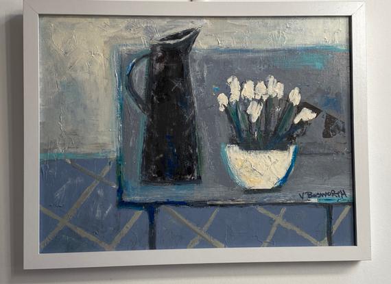 A black jug and bowl of white flowers on a grey table .  The space is flattened and the background consists of creams, and blue greys.