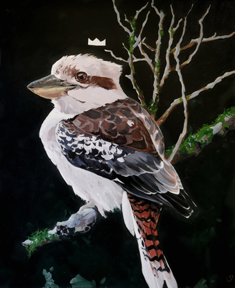 A kookaburra sitting on a branch with a small crown above his head.