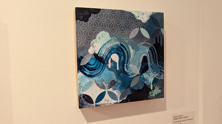 A painting in turquoise and blue featuring cloudlike forms, various geometric patterns and a brushstroke winding through the piece to symbolize wind and waves