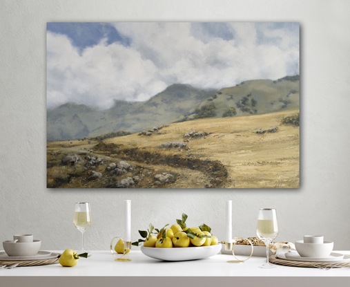 Wheat coloured grassy fields with billowing white fluffy clouds.