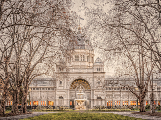 Winter photograph of the Royal Exhibition Building at Carlton Gardens featuring bare trees, central fountain and grunge effect captured by the photographer.