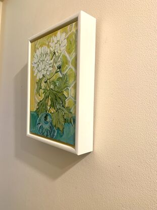 White chrysanthemums in a blue vase bathed in light