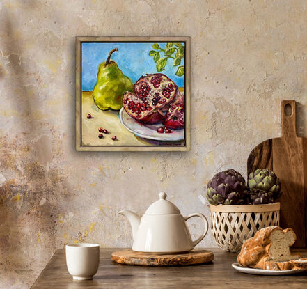 Still life setting with a green pear and cut pomegranate with seeds on a white plate