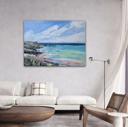 beach with rocky headland, flowers and coastal grass in foreground