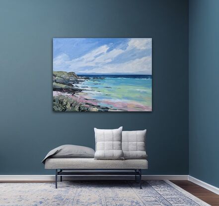 beach with rocky headland, flowers and coastal grass in foreground