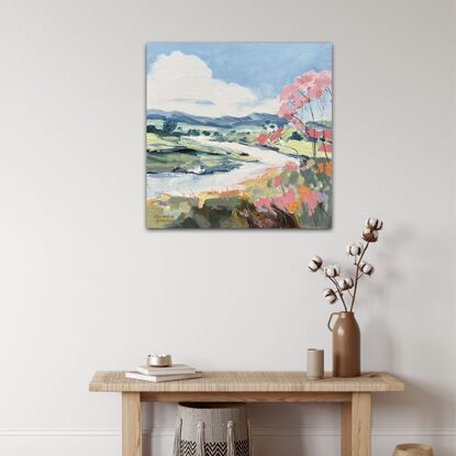 A small stream winding its way through the landscape with a pink blossom tree.