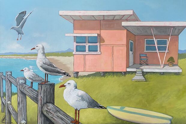 Beach shack on bluff overlooking the ocean with seagulls on the fence.