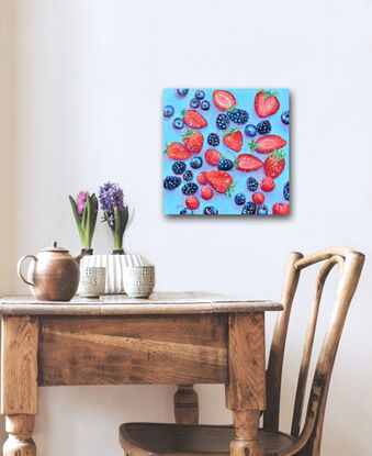 A square oil painting of blueberries, blackberries, raspberries and strawberries on a blue background. Some of the strawberries are sliced in half.