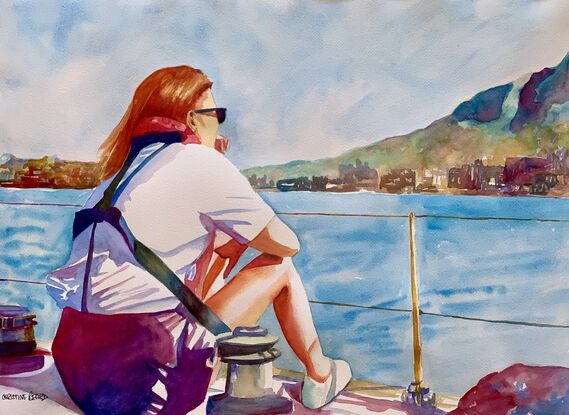 A crew member sits on the edge of a yacht and looks at the coast line.