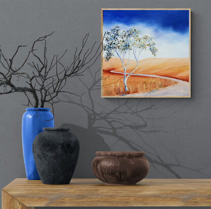 Australian landscape in yellows, oranges and deep blue sky with a single gum tree