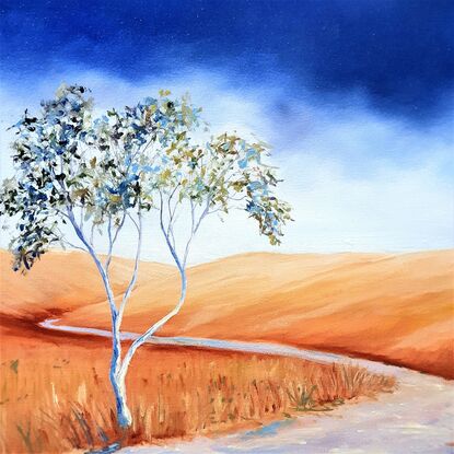 Australian landscape in yellows, oranges and deep blue sky with a single gum tree