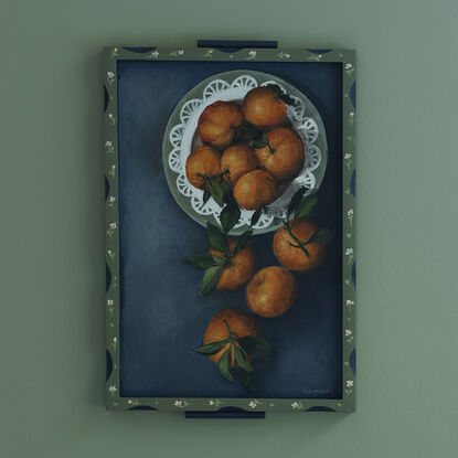 Painting of still life tangerines in a green patterned frame.