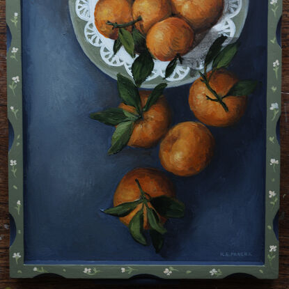 Painting of still life tangerines in a green patterned frame.