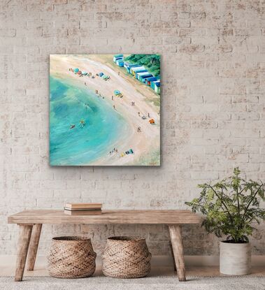 People on the beach. Colourful bathing boxes, beach umbrellas and three kayakers. Aerial view of an Australian beach.