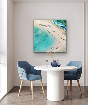 People on the beach. Colourful bathing boxes, beach umbrellas and three kayakers. Aerial view of an Australian beach.